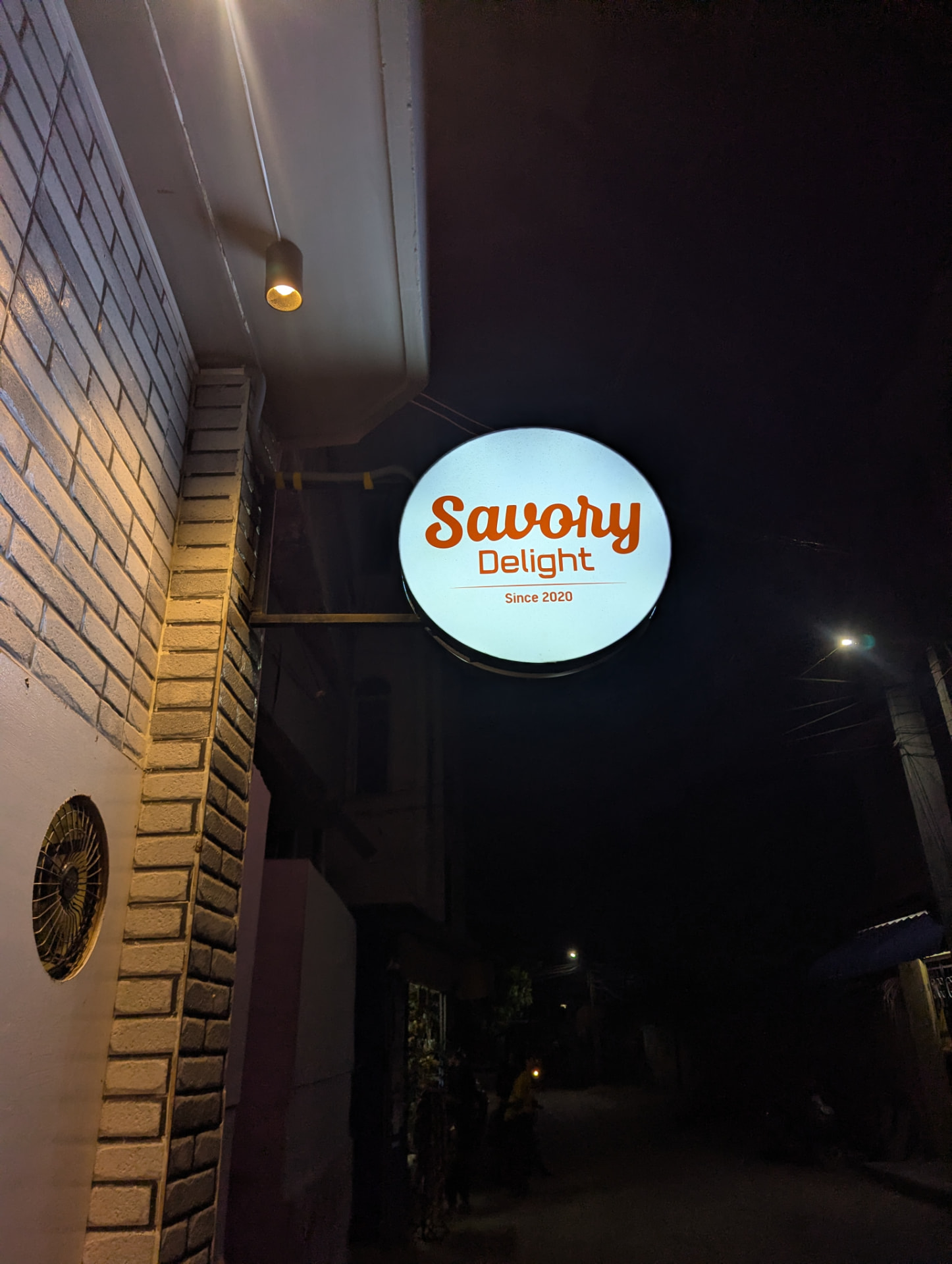 The illuminated Savory Delight sign outside the Keelakarai outlet at night